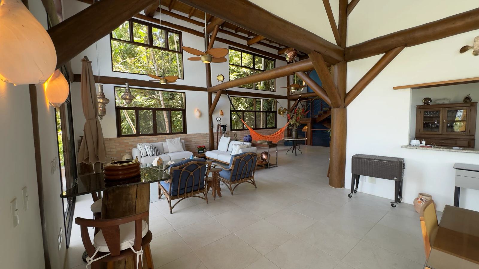 Sala principal da Villa 231 destacando a arquitetura em madeira aparente e pé-direito elevado.
