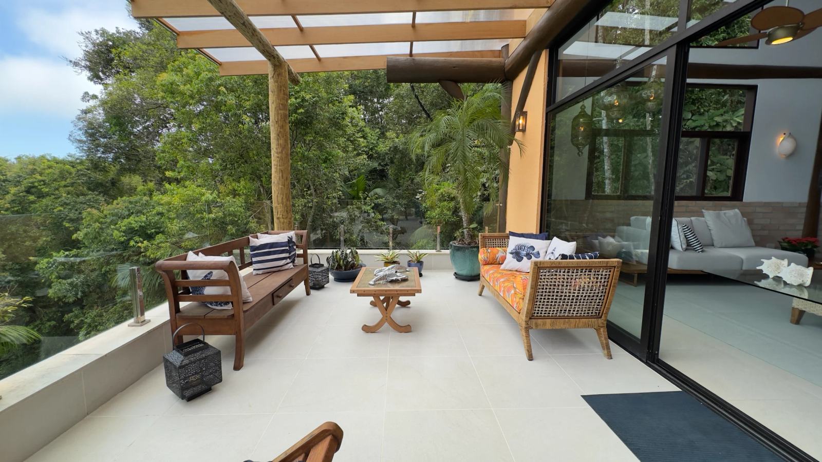 Lounge da varanda da Villa 231 com sofás e vista panorâmica para o mar.