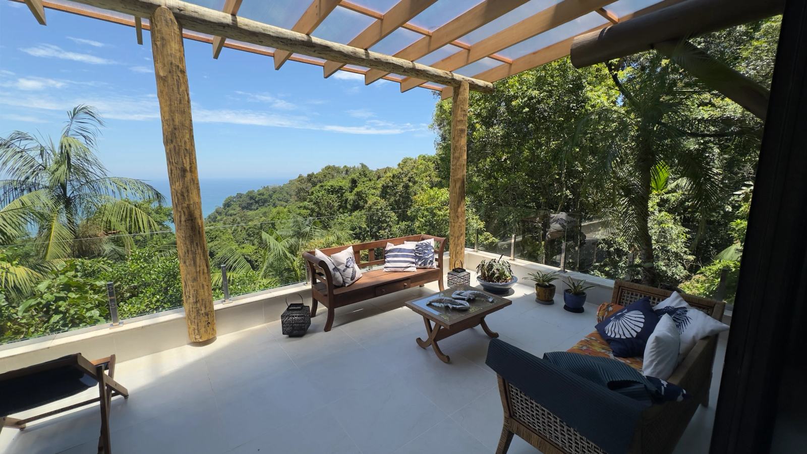 Varanda panorâmica da Villa 231 com vista para o mar e área de descanso.