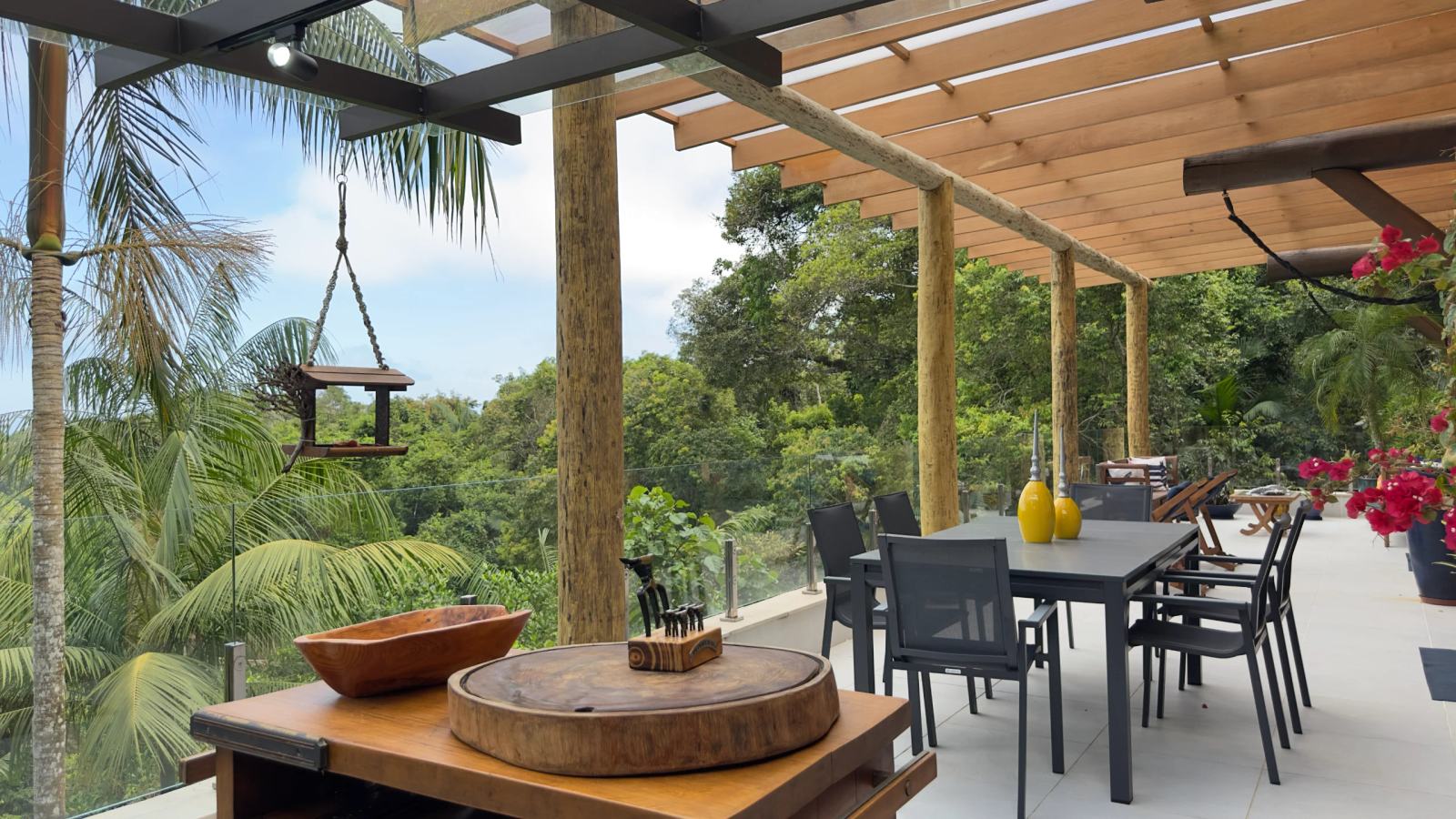 Varanda gourmet da Villa 231 com decoração rústica e vista para o oceano.