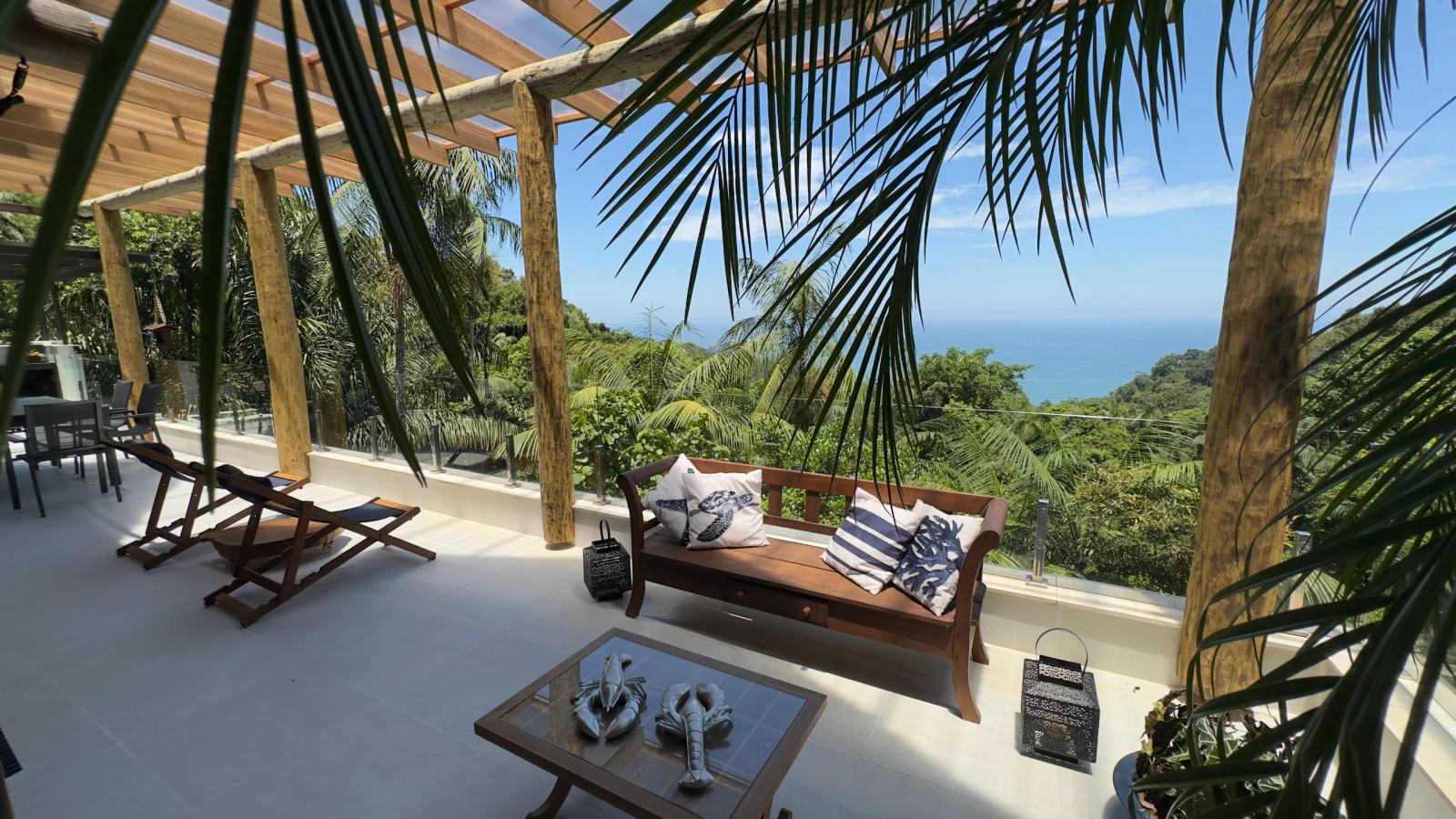 Sofá na varanda da Villa 231 com vista privilegiada para o mar e a natureza.