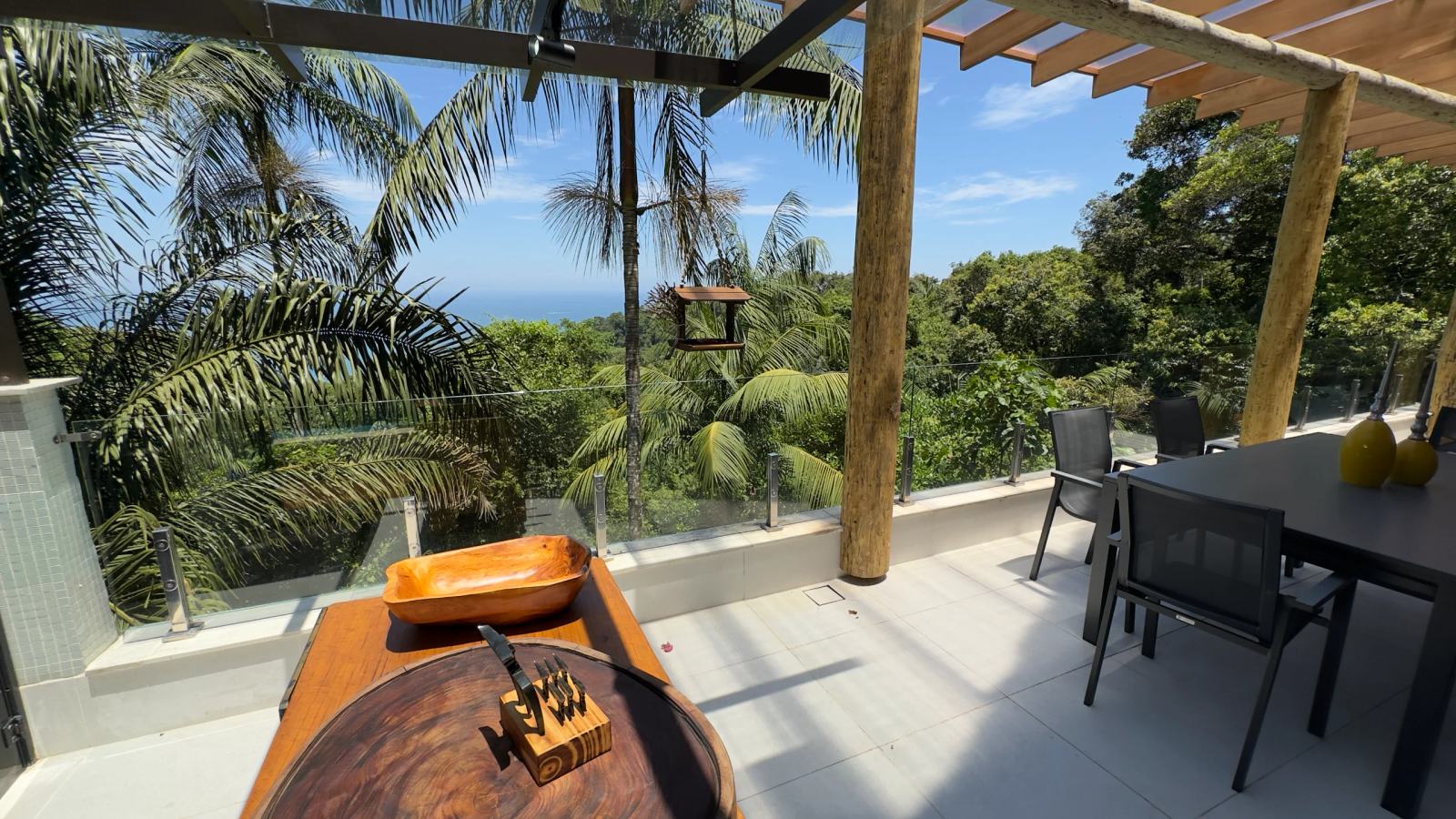 Mesa da varanda da Villa 231 com vista para o mar e paisagem tropical.